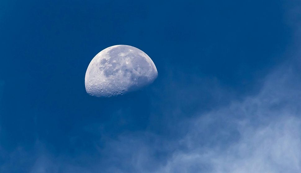 The moon is in the blue sky with clouds